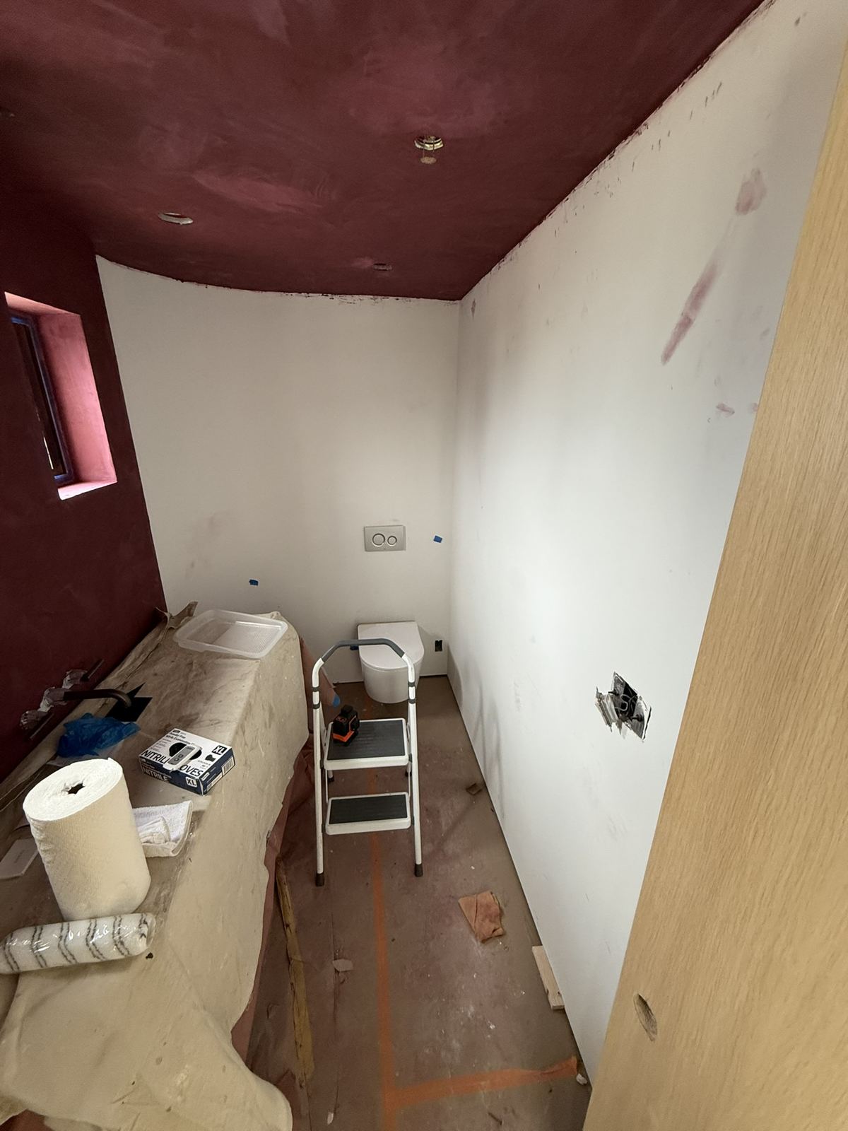 Powder room with bare primed drywall before wallpaper installation