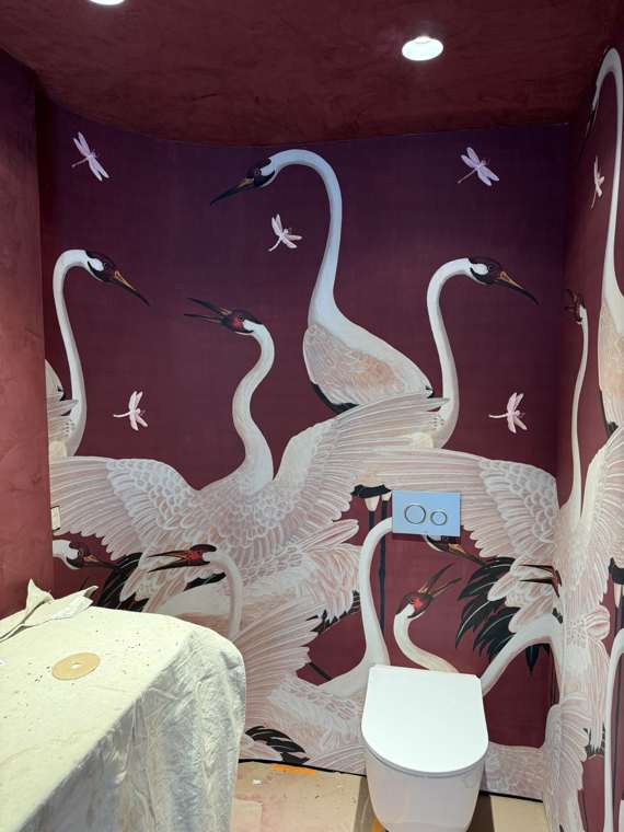 Heron-print mural following a curved wall